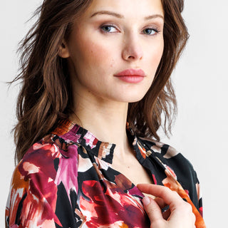 Woman wearing a floral blouse against a plain background